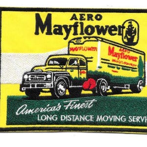 May include: Embroidered patch featuring a yellow Aero Mayflower moving truck. The patch has a black border and includes the text "Aero Mayflower" and "America's Finest Long Distance Moving Service."