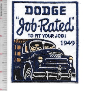 Op de afbeelding: Geborduurde patch met een vintage blauwe Dodge-truck met de tekst "DODGE Job-Rated TO FIT YOUR JOB!" en het jaartal "1949". De patch heeft een witte rand en staat op een witte achtergrond.