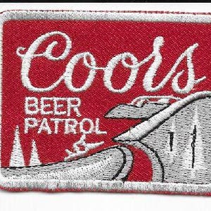 May include: Embroidered patch with a red background and white border. The patch features the word "Coors" in white script, with "BEER PATROL" below. A stylized mountain and river scene is also depicted.