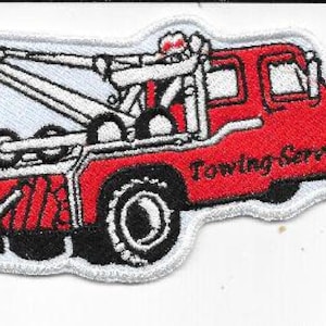 Puede incluir: Parche bordado que representa una grúa roja con neumáticos negros y detalles blancos. El texto "Towing Service" se muestra en el lateral. El parche tiene un borde blanco y está diseñado para su aplicación en ropa o accesorios.