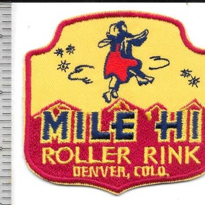 May include: Embroidered patch with a yellow background and a red border. The patch features a skater in a red dress and blue top, with the words "MILE HI ROLLER RINK DENVER, COLO." in blue and red. The patch is approximately 3 inches wide.
