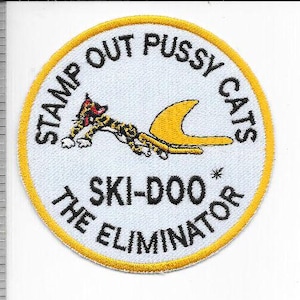May include: Embroidered patch with a white background and a yellow border. The patch features a cartoon cat with a yellow fin, and the text "STAMP OUT PUSSY CATS" and "SKI-DOO THE ELIMINATOR" in black.
