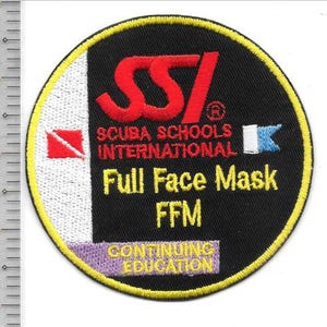 Könnte beinhalten: Ein kreisförmiger gestickter Aufnäher mit schwarzem Hintergrund und gelbem Rand. Er zeigt das rote SSI-Logo, den Text SCUBA SCHOOLS INTERNATIONAL, Full Face Mask FFM und CONTINUING EDUCATION. Ein Lineal zeigt einen Durchmesser von ca. 8,9 cm.