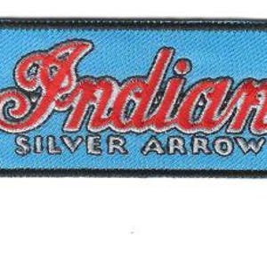 May include: A rectangular patch with a light blue background and a black border. The patch features the word "Indian" in red script, with "SILVER ARROW" below in silver. A silver arrow points left.
