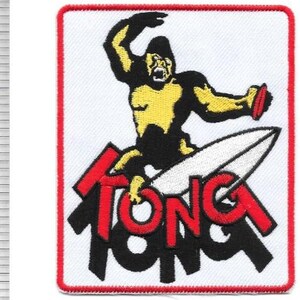 May include: Embroidered patch featuring a gorilla riding a surfboard. The gorilla is yellow and black, holding a red object. The word "TONGA" is in red and black letters on a white background with a red border.
