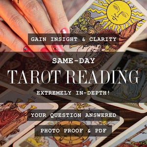 May include: A hand with a spider ring holding a tarot card with a yellow sun illustration. The card is part of a deck with text that reads "TAROT READING" and "GAIN INSIGHT & CLARITY". Other cards are visible.