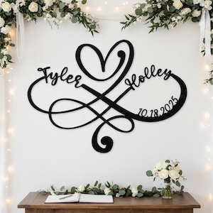 May include: A black metal wall sign featuring an infinity symbol intertwined with a heart shape. The sign includes the names Tyler and Holley in a cursive script, along with the date 10.18.2025 integrated into the design of the infinity loop.