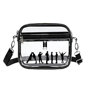 May include: Clear crossbody bag with a black trim, zipper, and adjustable strap. The bag features a black silhouette of seven figures and the letters "BTS" in white.