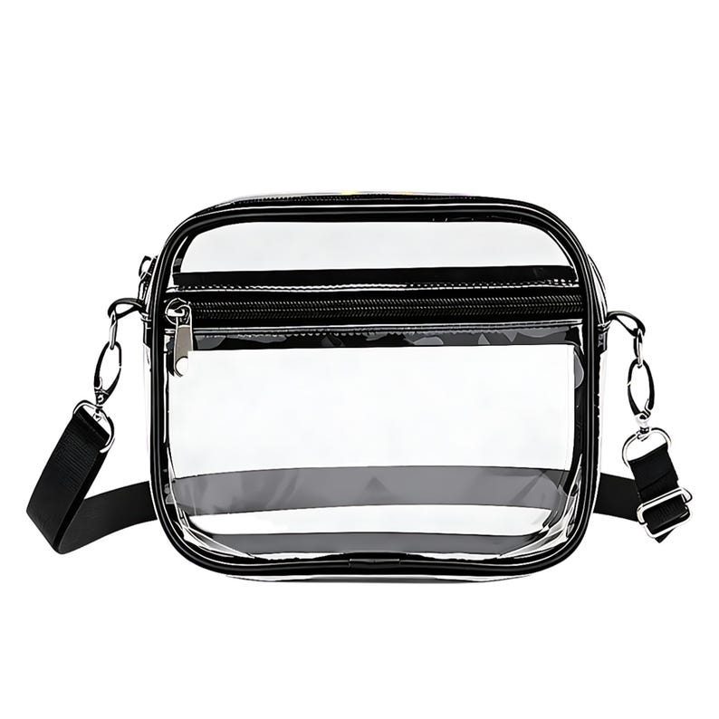 May include: A clear, rectangular crossbody bag with a black trim and zipper. The bag has a black adjustable shoulder strap and silver-tone hardware. The transparent design allows visibility of the contents.