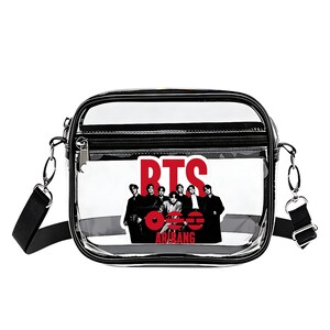 May include: Clear crossbody bag with a black trim and a black adjustable strap. The bag features a graphic of seven people and the red text "BTS" and "ARMY". The bag has a zipper closure and silver hardware.