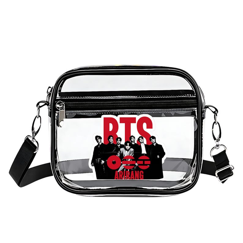 May include: Clear crossbody bag with a black trim and a black adjustable strap. The bag features a graphic of seven people and the red text "BTS" and "ARMY". The bag has a zipper closure and silver hardware.