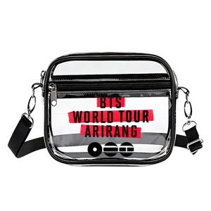 May include: Clear crossbody bag with black trim and a black adjustable strap. The bag features the text "BTS WORLD TOUR ARIRANG" in red. The bag has a zippered top and a small front pocket.