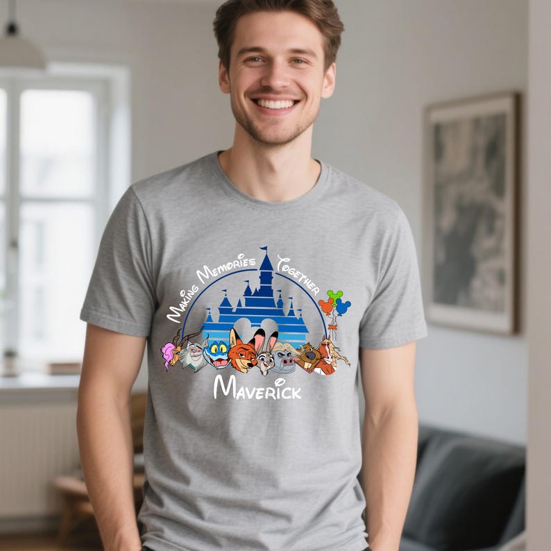 Puede incluir: Camiseta gris con un dise&ntilde;o de castillo azul, el texto "Making Memories Together" y el nombre "Maverick" en blanco. El dise&ntilde;o incluye personajes de dibujos animados y globos de colores.