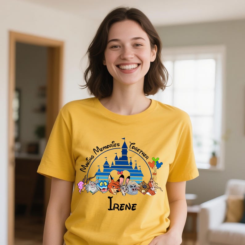 Puede incluir: Camiseta de color amarillo mostaza con un gr&aacute;fico de un castillo azul, personajes de dibujos animados y el texto "Making Memories Together" e "Irene". La camiseta tiene mangas cortas y la lleva una persona.