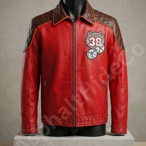 May include: A red leather jacket featuring brown quilted leather shoulders, a front zipper, and a patch on the chest displaying the text Lucky 38 with two dice. The jacket includes silver metal studs along the hem and cuffs, and a collar.