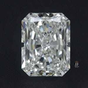 Può includere: Un diamante a taglio radiante di forma rettangolare, che mostra un design brillante e sfaccettato. La gemma chiara e incolore brilla su uno sfondo scuro, evidenziando la sua struttura interna e la rifrazione della luce. L'immagine è un primo piano, che enfatizza la chiarezza e il taglio del diamante.