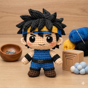 Puede incluir: Muñeca de ganchillo hecha a mano de un personaje de dibujos animados con pelo negro puntiagudo, una diadema azul y amarilla y un atuendo azul. La muñeca está sobre una superficie de madera, con un cuenco de madera con botones, hilo y otros suministros de artesanía.