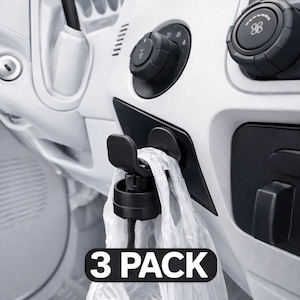 May include: Black plastic car trash bag holder with a white plastic bag attached. The holder is mounted on a white car dashboard. The text "3 PACK" is displayed on the image.