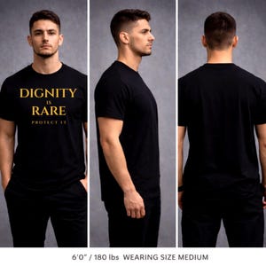 May include: Black t-shirt with the text "DIGNITY IS RARE PROTECT IT" in gold lettering. The shirt is displayed from multiple angles, showcasing the front, side, and back views. The model is wearing a medium size.