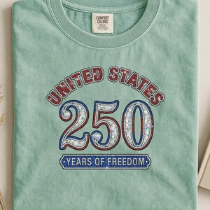 Green t-shirt with "United States 250 Years of Freedom" graphic.