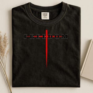 Koszulki z napisem „Wolność”, koszulka z symbolem krzyża, grafika „Wolność”, projekt oświadczenia protestacyjnego, odzież niepodległościowa, koszulka z mocnym przesłaniem, wyjątkowy prezent