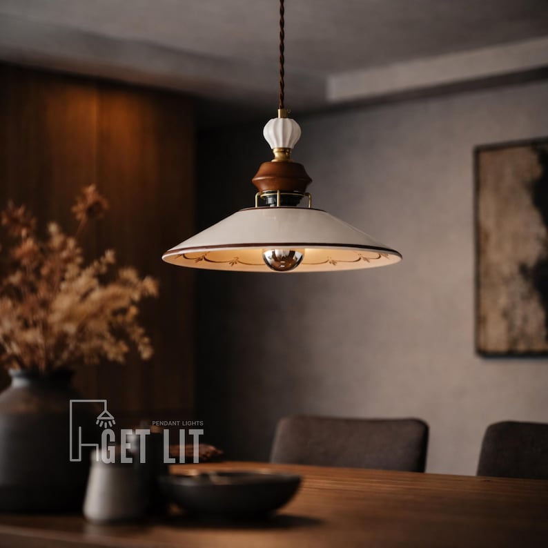 May include: A pendant light fixture with a white lampshade and a brown wooden base. The light has a decorative design around the edge of the shade and a brown cord. The text "GET LIT" is visible in the lower left corner.