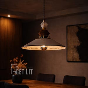 May include: A pendant light fixture with a white lampshade featuring a black floral design. The light has a brown and gold accent and a white decorative top. The text "GET LIT" is visible at the bottom of the image.