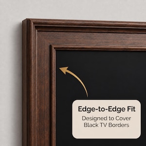 May include: A dark brown wood-textured frame with a decorative molding profile. A cream-colored rectangular label with rounded corners features a gold arrow pointing toward the frame and the text: Edge-to-Edge Fit Designed to Cover Black TV Borders.