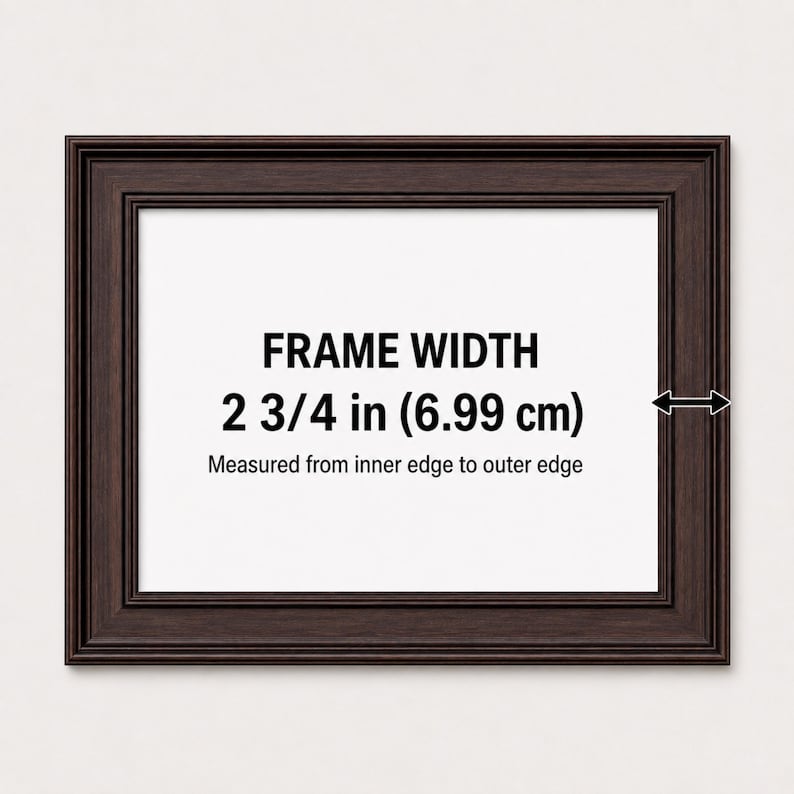 May include: A dark brown rectangular picture frame with a stepped profile. The center displays the text FRAME WIDTH 2 3/4 in (6.99 cm) Measured from inner edge to outer edge, with a black arrow indicating the width of the frame border.