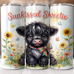 May include: A white tumbler featuring a black Highland cow illustration with a colorful bow, surrounded by sunflowers, butterflies, and wildflowers. The text "Sunkissed Sweetie" is displayed at the top. This tumbler is perfect for cold beverages.
