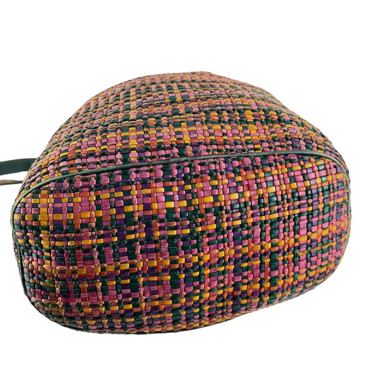 May include: A colourful woven handbag with a rounded shape. The bag features a pattern of pink, orange, yellow, green, and purple squares. The bag has a dark green trim and a strap.