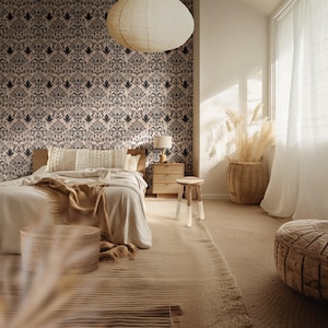 May include: A bedroom with a patterned wallpaper, a bed with a beige blanket, and a woven rug. A round, woven light fixture hangs from the ceiling. A small wooden stool with white-painted legs sits near a nightstand.