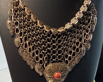 Collana bavaglino vintage in stile boho, con frange a catena color ottone e ciondolo cabochon rosso.