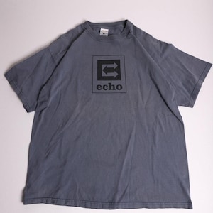Puede incluir: Camiseta gris con un cuadrado negro con dos flechas opuestas y la palabra "echo" debajo. La camiseta tiene mangas cortas y cuello redondo.
