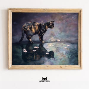 May include: A framed art print featuring a tortoiseshell cat standing near a pool of water with floating pink flowers. The cat's reflection is visible in the water. The background has a dark, moody color palette.