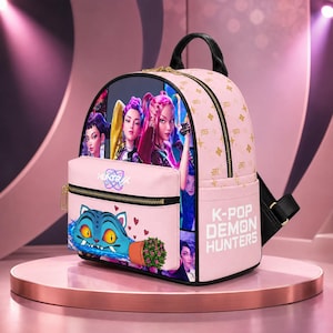 May include: A light pink backpack featuring a graphic of three characters and a blue cat-like creature. The front pocket displays the text HUNTR and the lower side features the text K-POP DEMON HUNTERS. The bag has black straps and gold zippers.