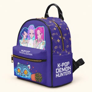 May include: A purple backpack featuring a graphic of three anime-style characters and the text K-POP DEMON HUNTERS. The front pocket displays a blue cat-like creature and a potted plant. The side panel also features the text K-POP DEMON HUNTERS.