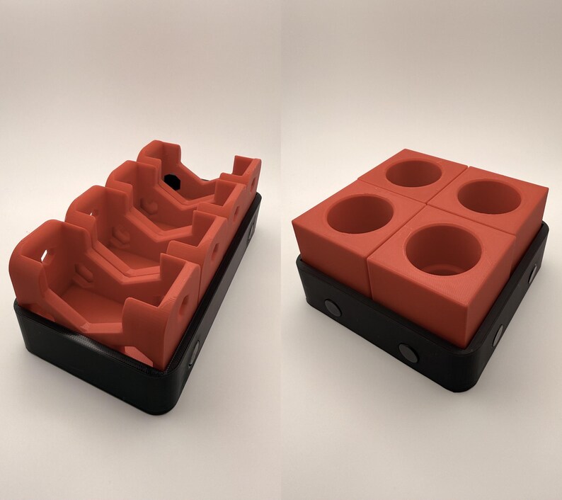 Puede incluir: Dos vistas de un juego de portavasos modular de color rojo anaranjado. Una muestra las piezas apiladas, la otra las muestra separadas. Los portavasos se asientan en una base negra con cierres magn&eacute;ticos. El juego est&aacute; dise&ntilde;ado para sostener cuatro tazas.