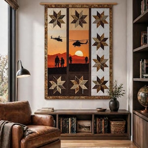 May include: A large, rectangular quilt with a military theme. The quilt features panels with star patterns and silhouettes of helicopters and figures against a sunset backdrop. The color palette includes browns, tans, and oranges.