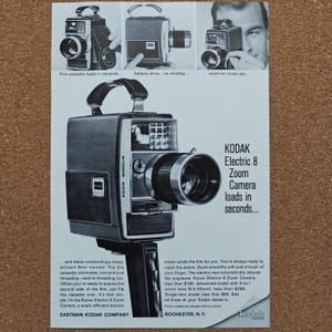 May include: A vintage black and white advertisement for the Kodak Electric 8 Zoom Camera. The print features a large camera with a top handle and lens, alongside three smaller images demonstrating its features, with text detailing the product.