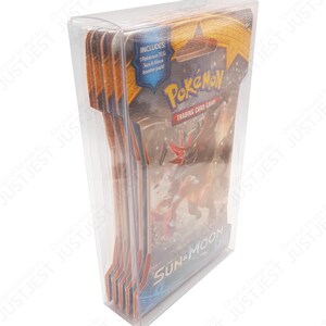 May include: A clear plastic case containing multiple Pok&eacute;mon TCG Sun & Moon booster packs. The packs feature the Pok&eacute;mon logo and artwork of a red and orange creature. The case includes a sticker that says "Includes: 1 Pok&eacute;mon TCG Sun & Moon booster pack!"