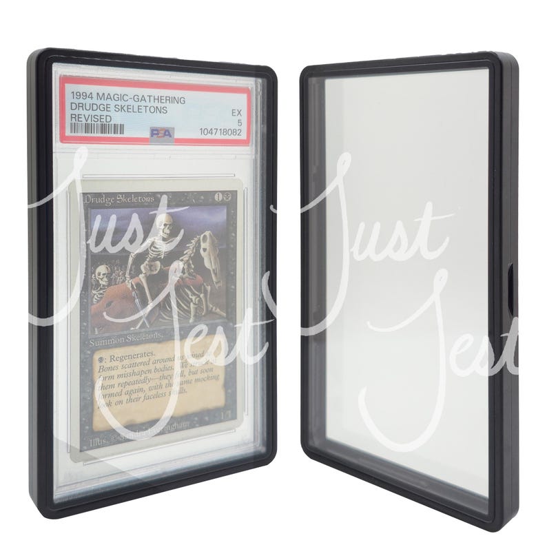 May include: A graded Magic: The Gathering card, "Drudge Skeletons," from the Revised edition, encased in a black protective holder. The card features skeletal figures and text. The holder is displayed next to an empty holder.