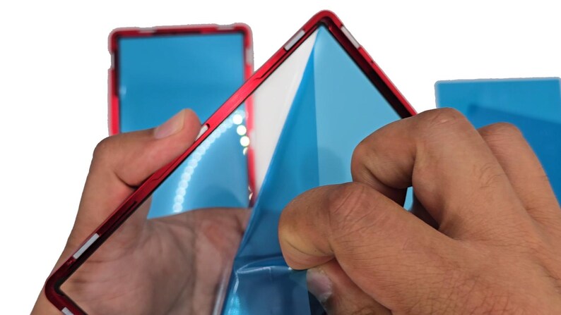 May include: A red frame with a blue protective film being peeled away. The frame has a white interior and is held by two hands. Additional frames with blue film are visible in the background.