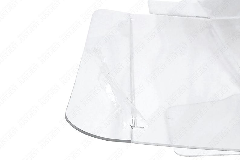 May include: A clear, transparent plastic object with a curved edge and multiple flat surfaces. The object appears to be folded or constructed from several pieces, with visible seams and a slightly reflective quality. The overall shape is geometric.