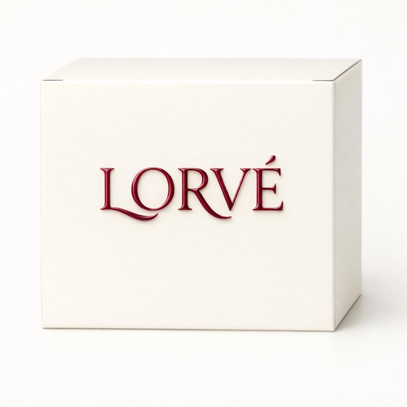 May include: A square, off-white cardboard box featuring the word LORV&Eacute; printed in a deep red, serif font on the front face. The box has a clean, matte finish and a simple, structured design, presenting a neutral appearance for packaging.