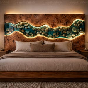 May include: A wooden headboard featuring a horizontal, wavy river-like inlay filled with smooth river stones and translucent blue resin. The inlay is backlit with warm LED lighting, contrasting against the natural wood grain of the headboard.