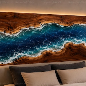 May include: A rectangular headboard featuring a natural wood grain border with a central river-like inlay of deep blue and turquoise resin. The resin section displays white, foamy wave patterns. The headboard is framed in black and has integrated lighting.