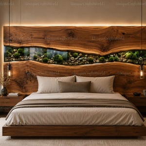 May include: A wooden headboard featuring a horizontal glass inlay filled with river stones and green moss. The headboard is integrated with warm LED backlighting and is positioned behind a bed with white bedding and a brown throw blanket.
