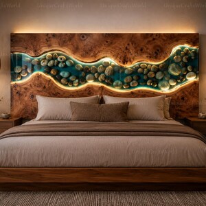 May include: A wooden headboard featuring a horizontal, wavy river-like inlay filled with smooth river stones and translucent blue resin. The inlay is backlit with warm LED lighting, contrasting against the natural wood grain of the headboard.