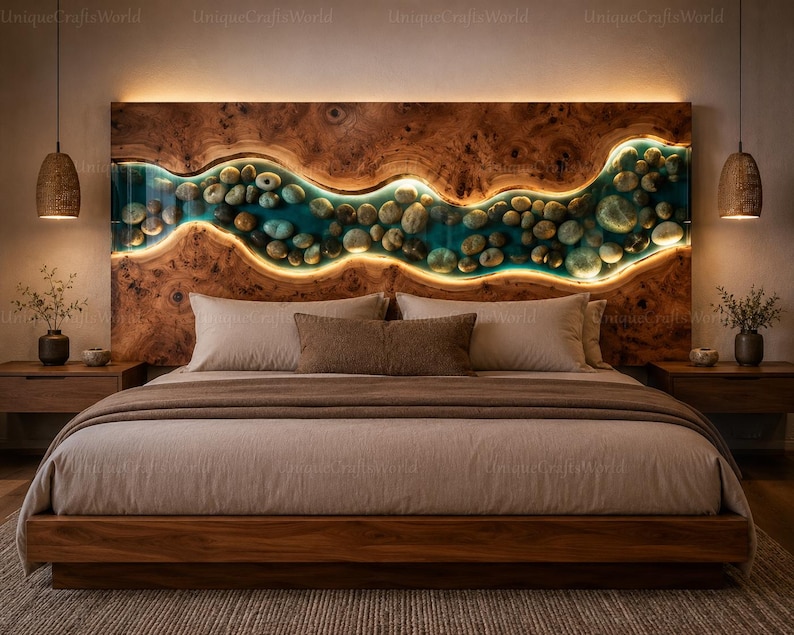 May include: A wooden headboard featuring a horizontal, wavy river-like inlay filled with smooth river stones and translucent blue resin. The inlay is backlit with warm LED lighting, contrasting against the natural wood grain of the headboard.